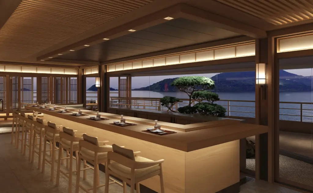 Akari hero | The Luxury Travel Atlas | The Luxury Travel Atlas Wood-clad Dining Area with a Long Central Counter and Stools, Overlooking a Lake and Mountains at Dusk.