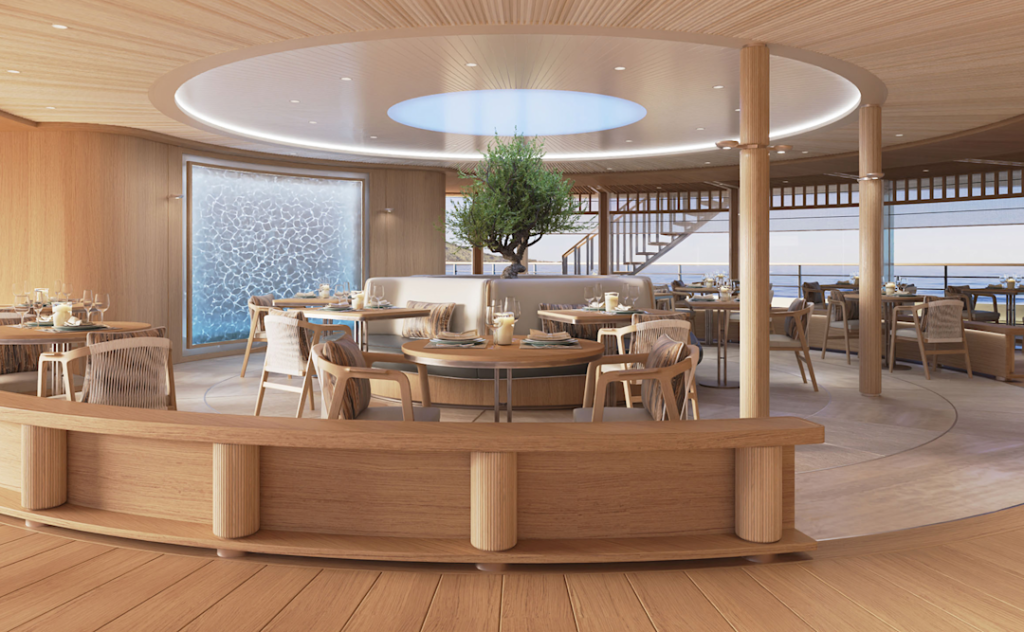 Amangati alira 03 1890x1167px | The Luxury Travel Atlas | The Luxury Travel Atlas Elegant Circular Dining Area with Wooden Furnishings, Central Planter Tree, and Ocean-view Windows.