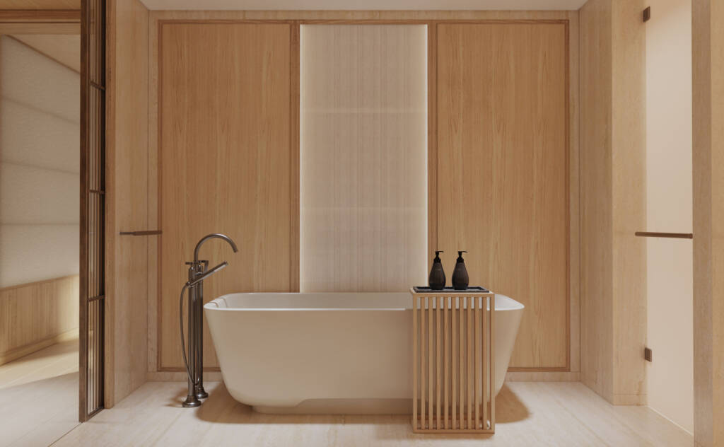 Freestanding white bathtub in a warm wood-paneled bathroom with a small wooden rack holding two black soap bottles on a tray.