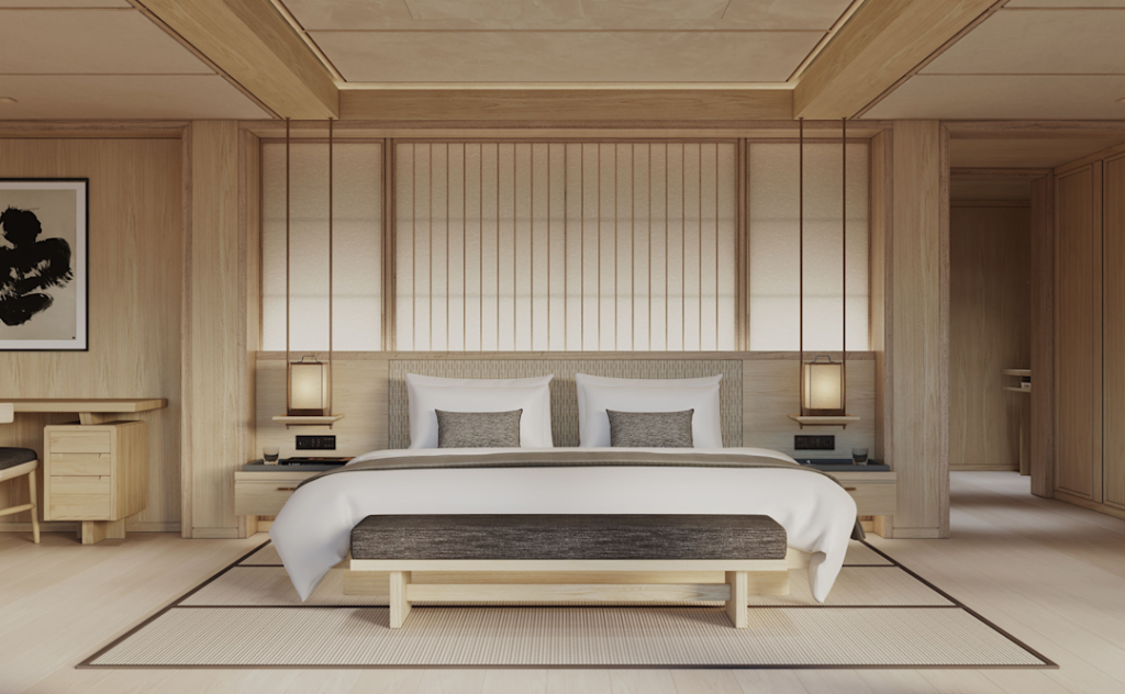 Minimalist hotel bedroom with a large bed, white linens, and a wooden bench at the foot.