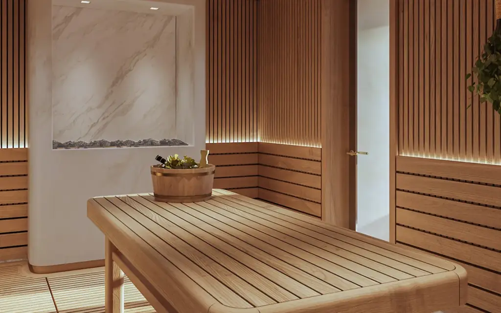 Amangati spa 07 1394x1394px | The Luxury Travel Atlas | The Luxury Travel Atlas Wood-paneled Sauna with a Long Wooden Bench, a Round Hot-water Bucket and Ladle on the Bench, and a Marble Wall Feature Nearby.