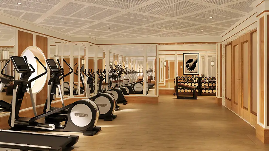 Hotel Gym with Treadmills and Ellipticals Along a Mirrored Wall and Wooden Floor, Weights Visible in the Background.