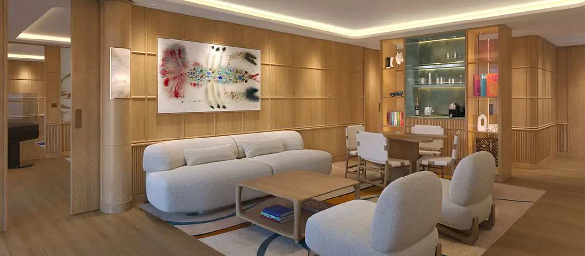 Modern wood-paneled living room with a beige curved sofa, two matching lounge chairs, and a light wooden coffee table. A dining area with a glass-front cabinet and shelves is in the background, and abstract art hangs on the wall.