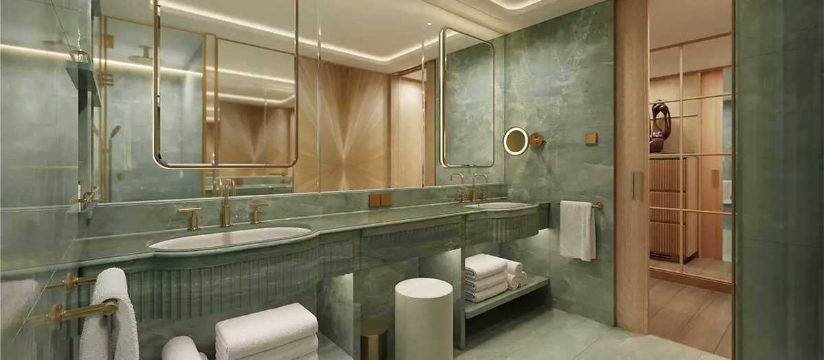 Luxurious green marble bathroom with twin sinks, gold fixtures, and large backlit mirrors, creating a spa-like feel.