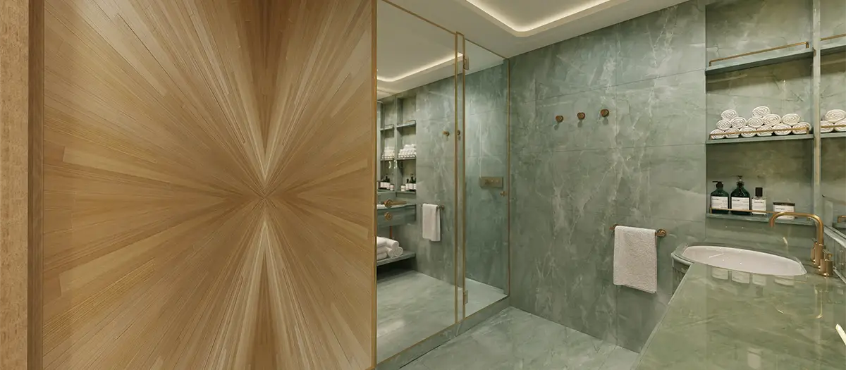 Luxurious spa-style bathroom with green marble walls, glass shower enclosure with gold trim, and a wooden paneled wall on the left.