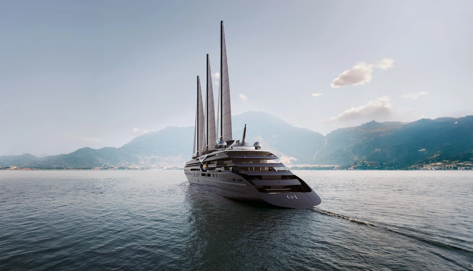 Luxurious multi-sail yacht gliding on calm sea with a coastal town and mountains in the background.