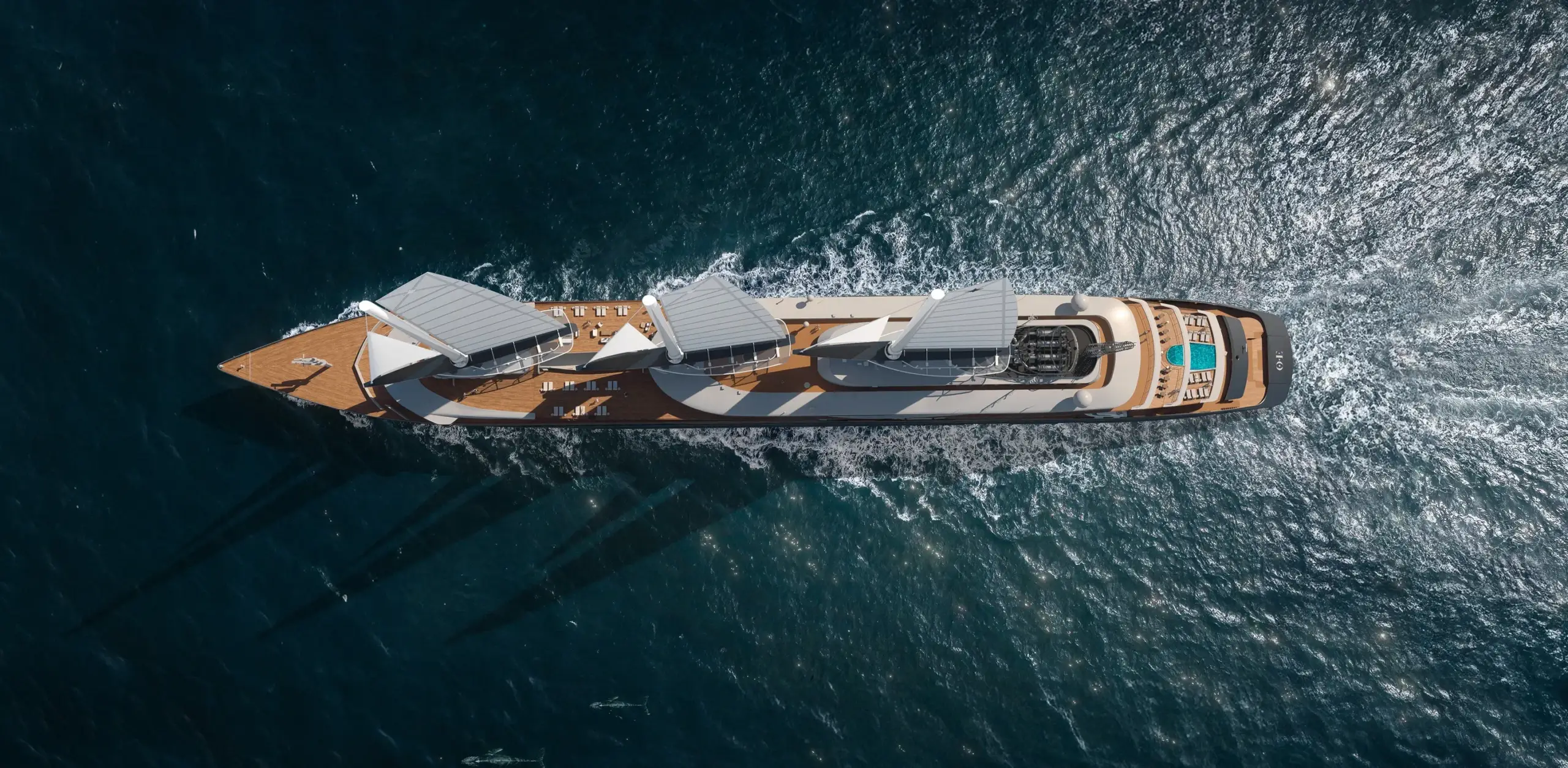 Aerial, top-down view of a large luxury yacht cruising on dark blue ocean water.