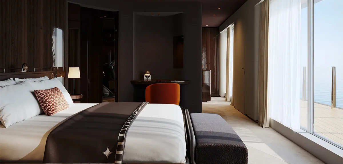 Luxurious hotel bedroom with a king bed, dark wood accents, and floor-to-ceiling windows overlooking the ocean.