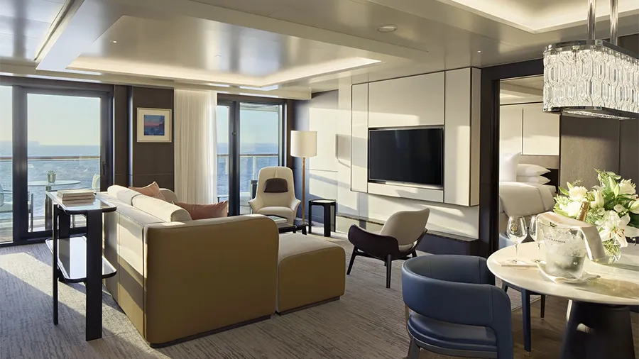 Luxurious Modern Lounge with Mustard Sofa, Chairs, and a Wall-mounted Tv Facing a Sea-view Balcony Far Windowed Doors.